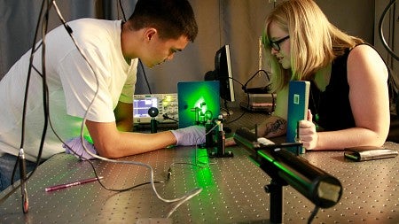 Two students looking under a microscope